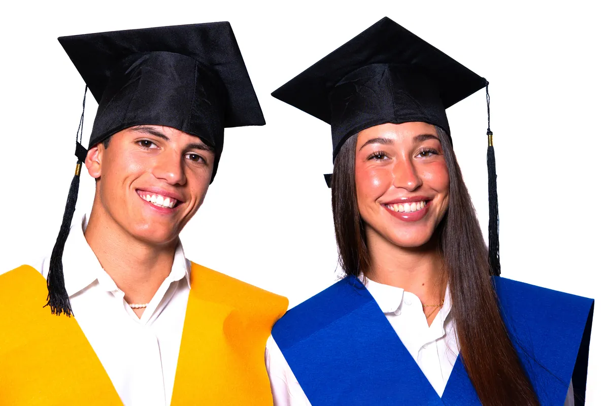 Dos estudiantes sonrientes con birrete y beca de graduación